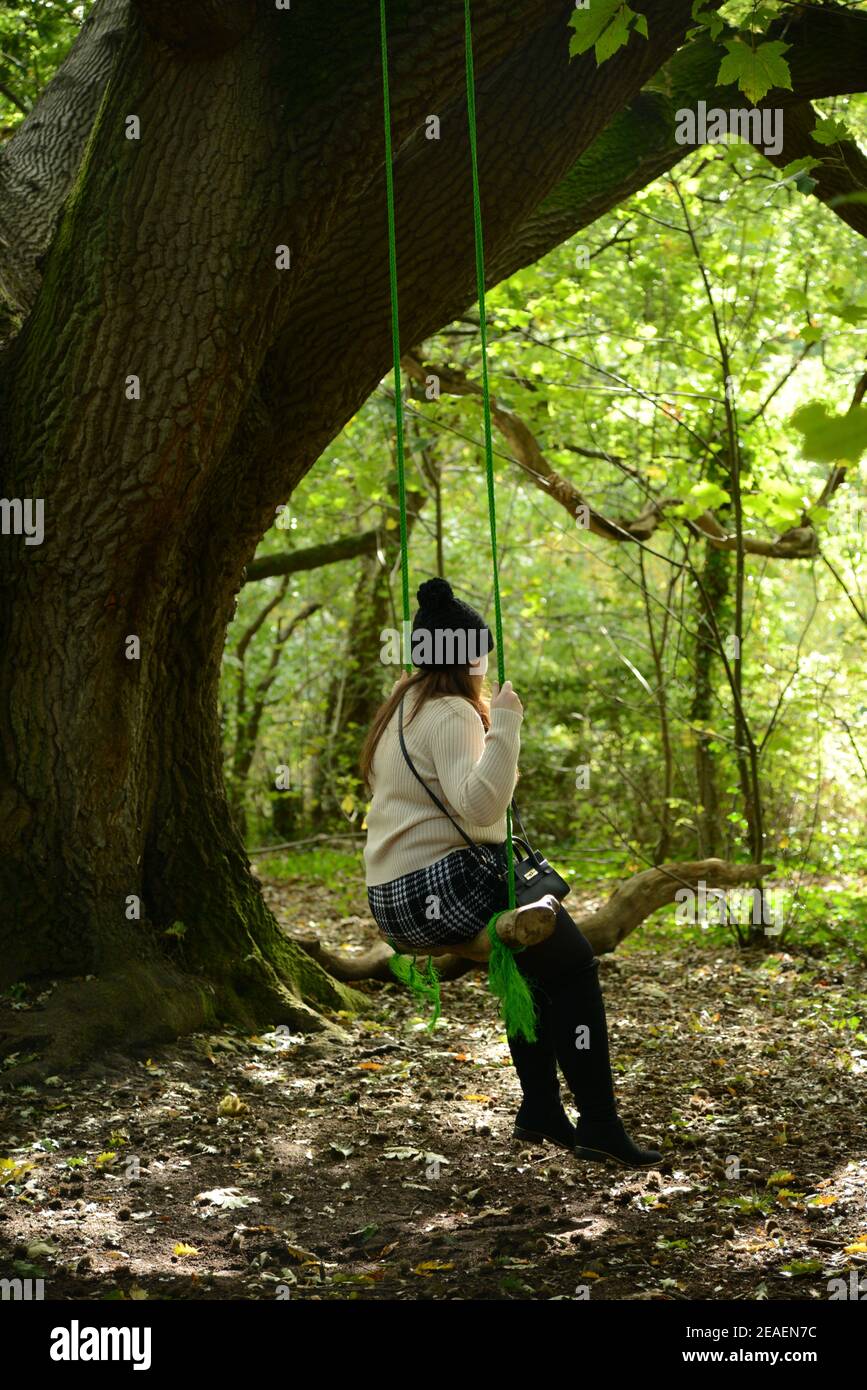 Giovani donne in altalena nei boschi Foto Stock