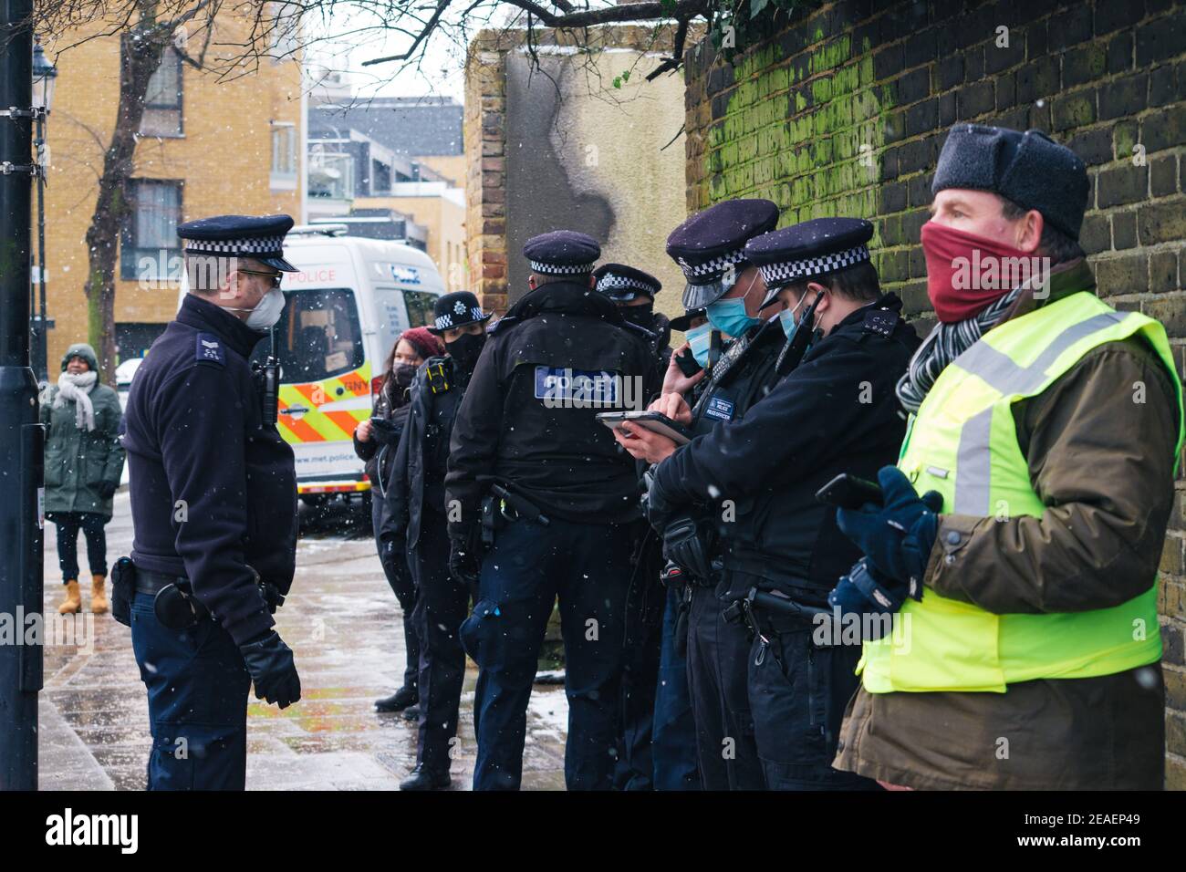 Londra, Regno Unito. 9 Feb 2021. Highbury Corner Efriction, una linea di polizia in piedi nella neve, non essendo molto socialmente distanziati. Highbury, Londra, Regno Unito 9 febbraio 2021. Credit: Denise Laura Baker/Alamy Live News Foto Stock