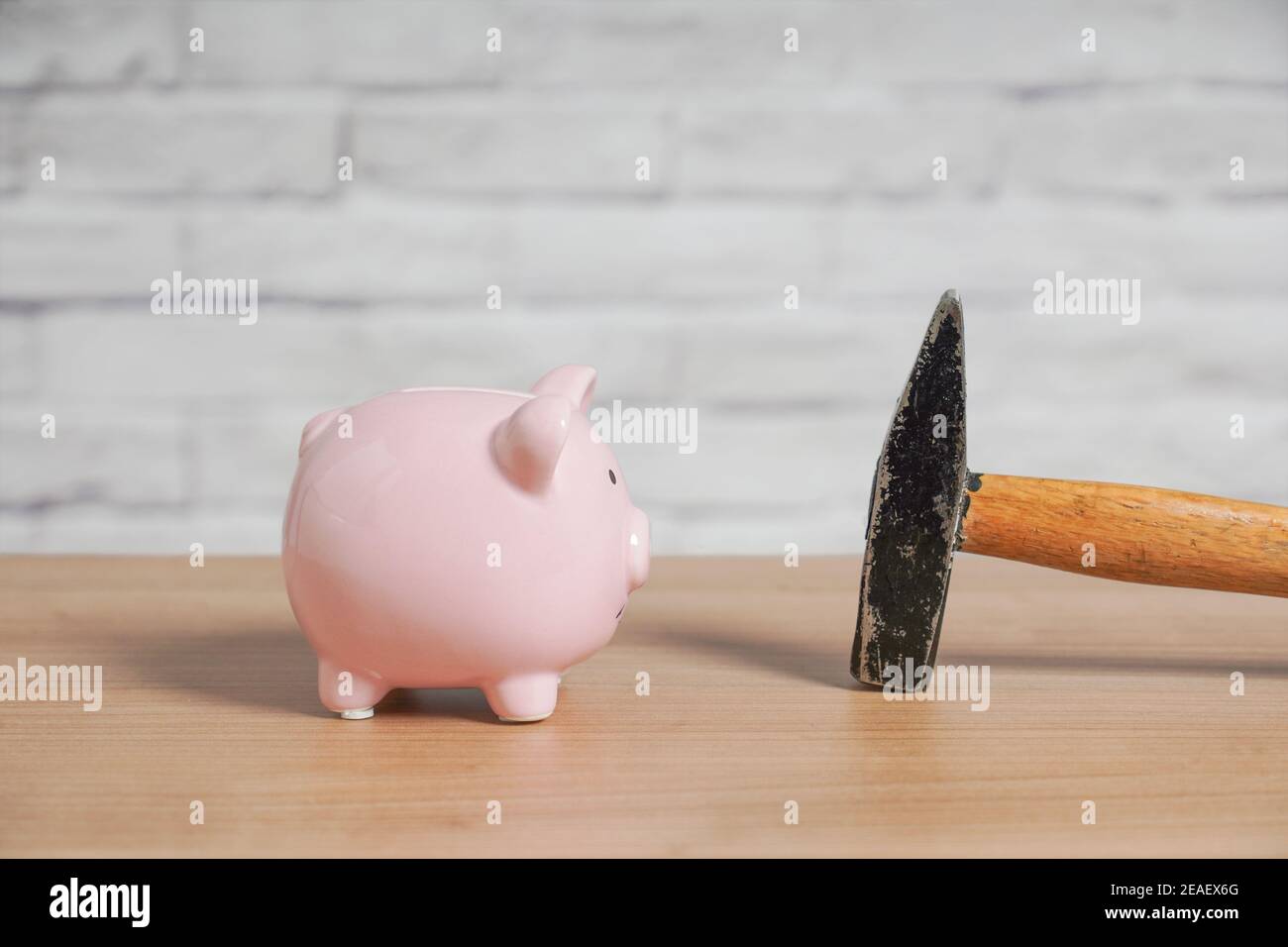 Banco e martello piggy - concetto di rottura o frantumazione piggybank o banca di moneta per saccheggio di risparmi Foto Stock