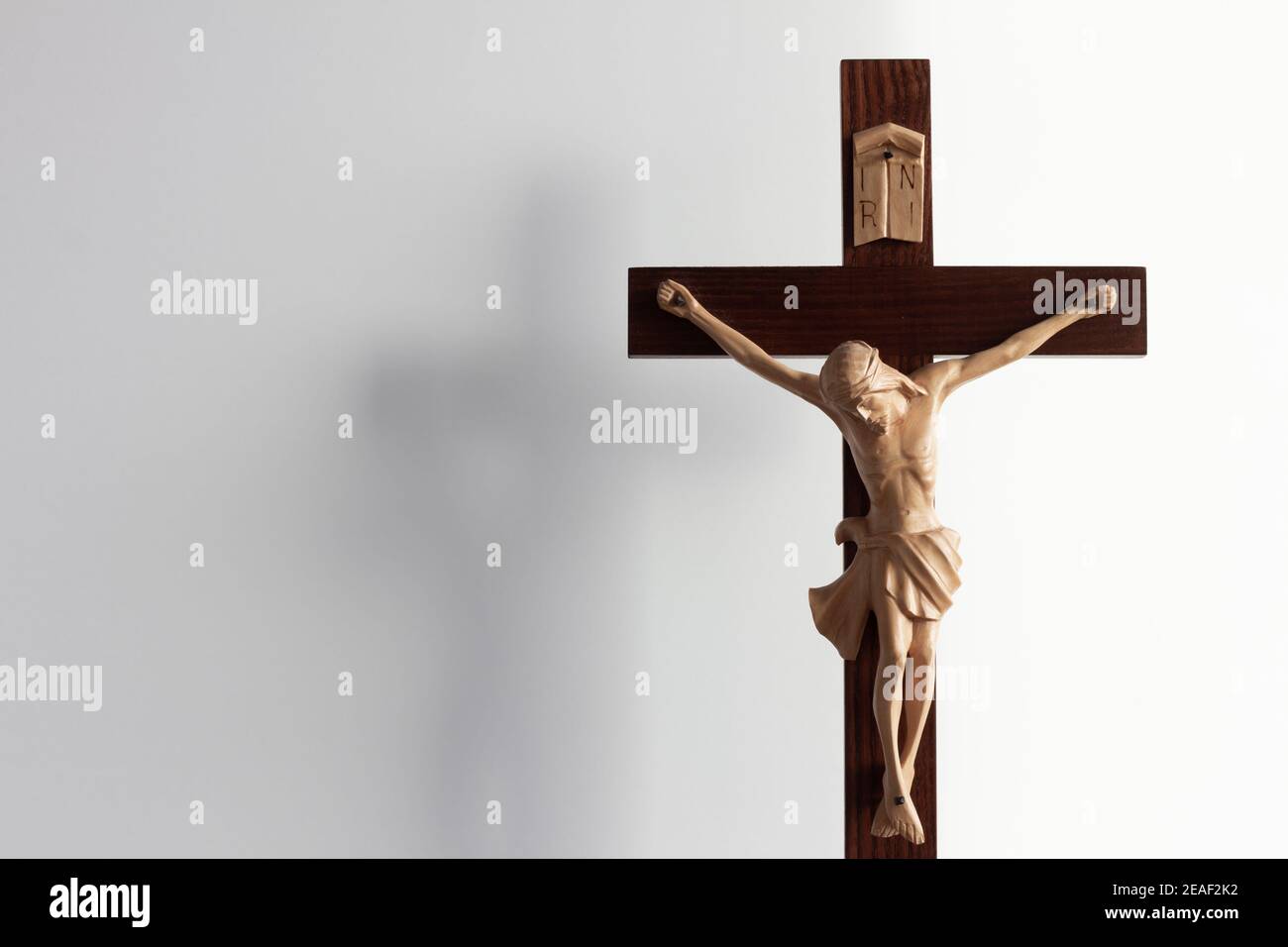 Croce crocifisso di legno con Gesù su sfondo bianco con copia spazio Foto Stock