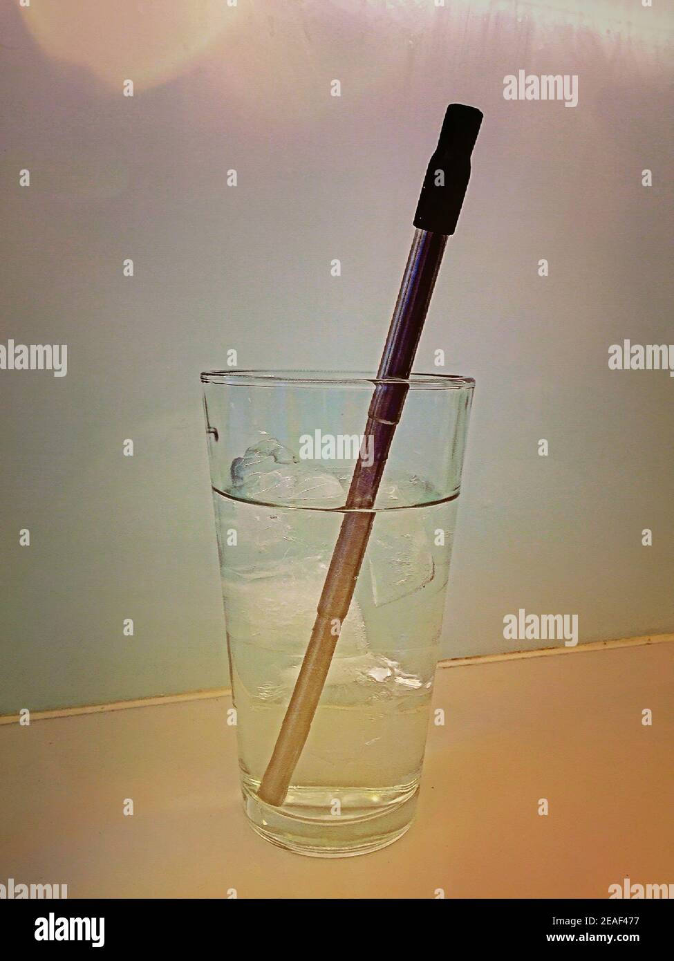 Acciaio inossidabile riutilizzabili paglia in uso in un bicchiere di acqua, STATI UNITI D'AMERICA Foto Stock