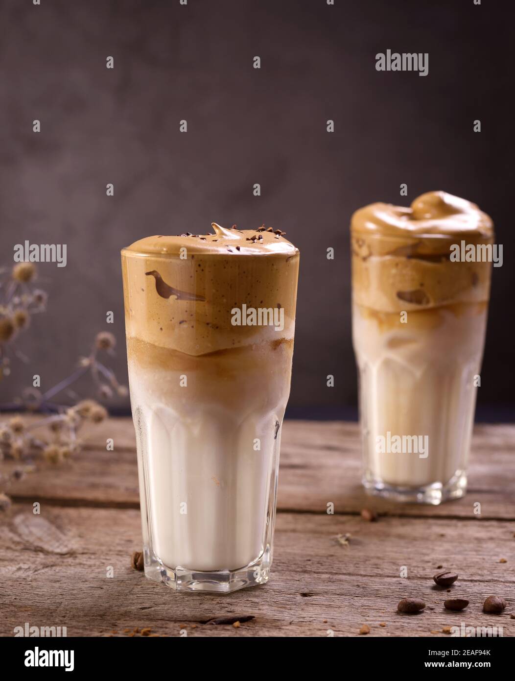 Caffè Dalgona. Bevanda ghiacciata montata con caffè istantaneo popolare in Corea cocktail cremoso in bicchieri alti. Fotografia di cibo con moody scuro Foto Stock