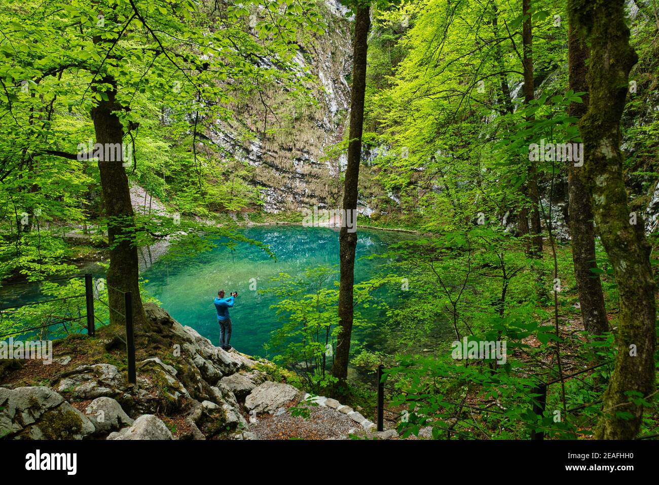 Uomo che scatta foto del lago selvaggio vicino Idrija Foto Stock