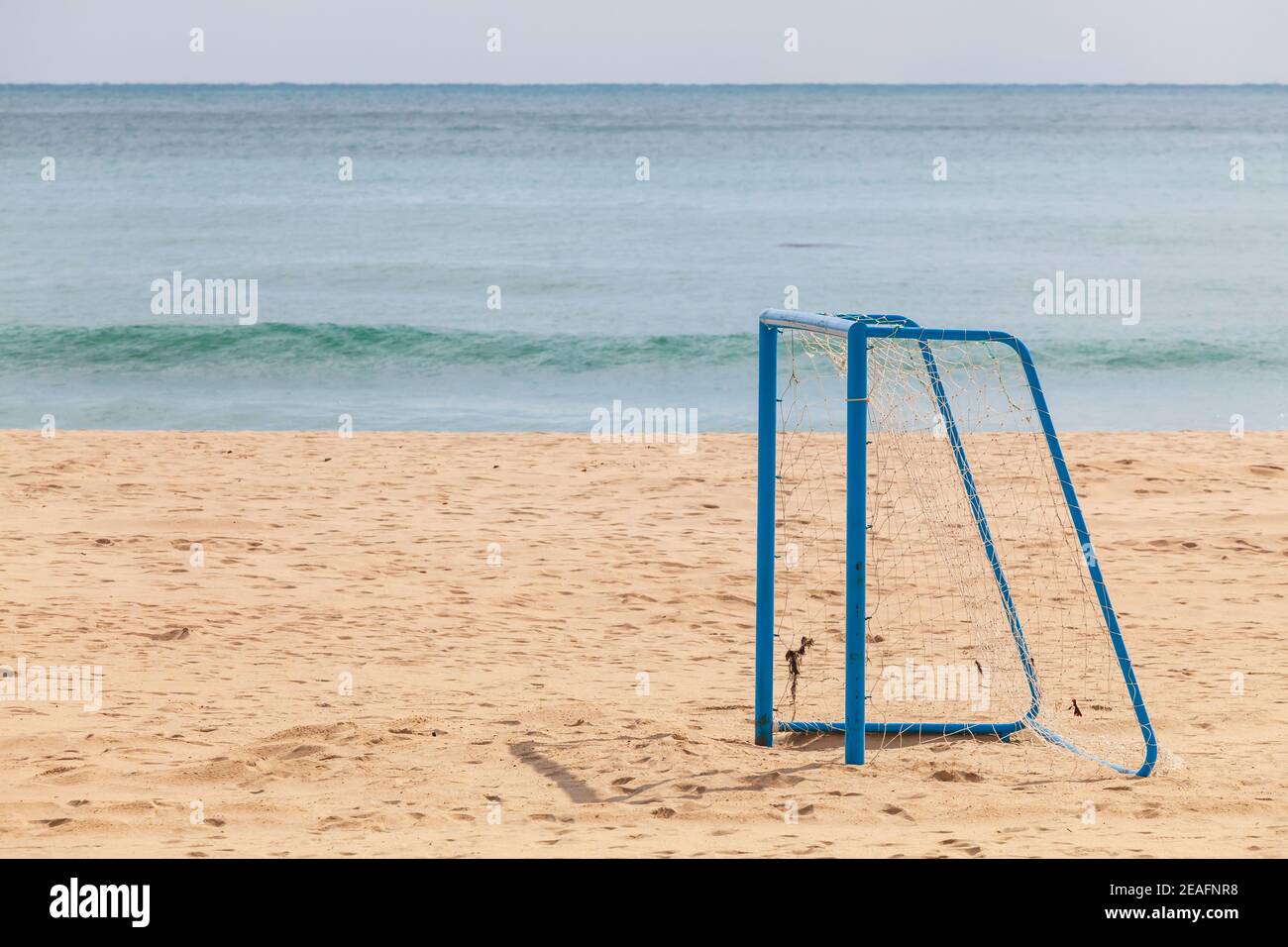 Un obiettivo di calcio blu vuoto si trova su una spiaggia di sabbia nella città di Busan, Corea del Sud Foto Stock