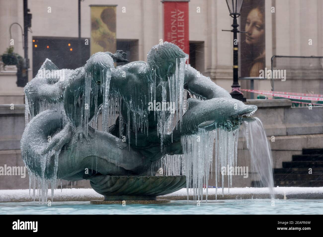 Londra, Regno Unito. 9 febbraio 2021. UK Weather: Una fontana ghiacciata coperta di ghiaccio in Trafalgar Square durante le luci della neve mentre il freddo portato da Storm Darcy continua. Credit: Stephen Chung / Alamy Live News Foto Stock
