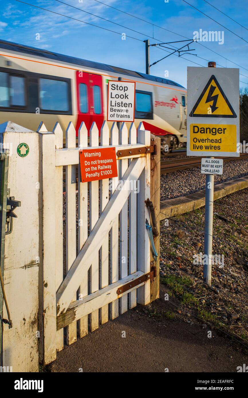 Treno pedonale porta d'attraversamento con passaggio del treno Grande Anglia - attraversamento non automatizzato di livello per pedoni con segnali di avvertimento. Foto Stock
