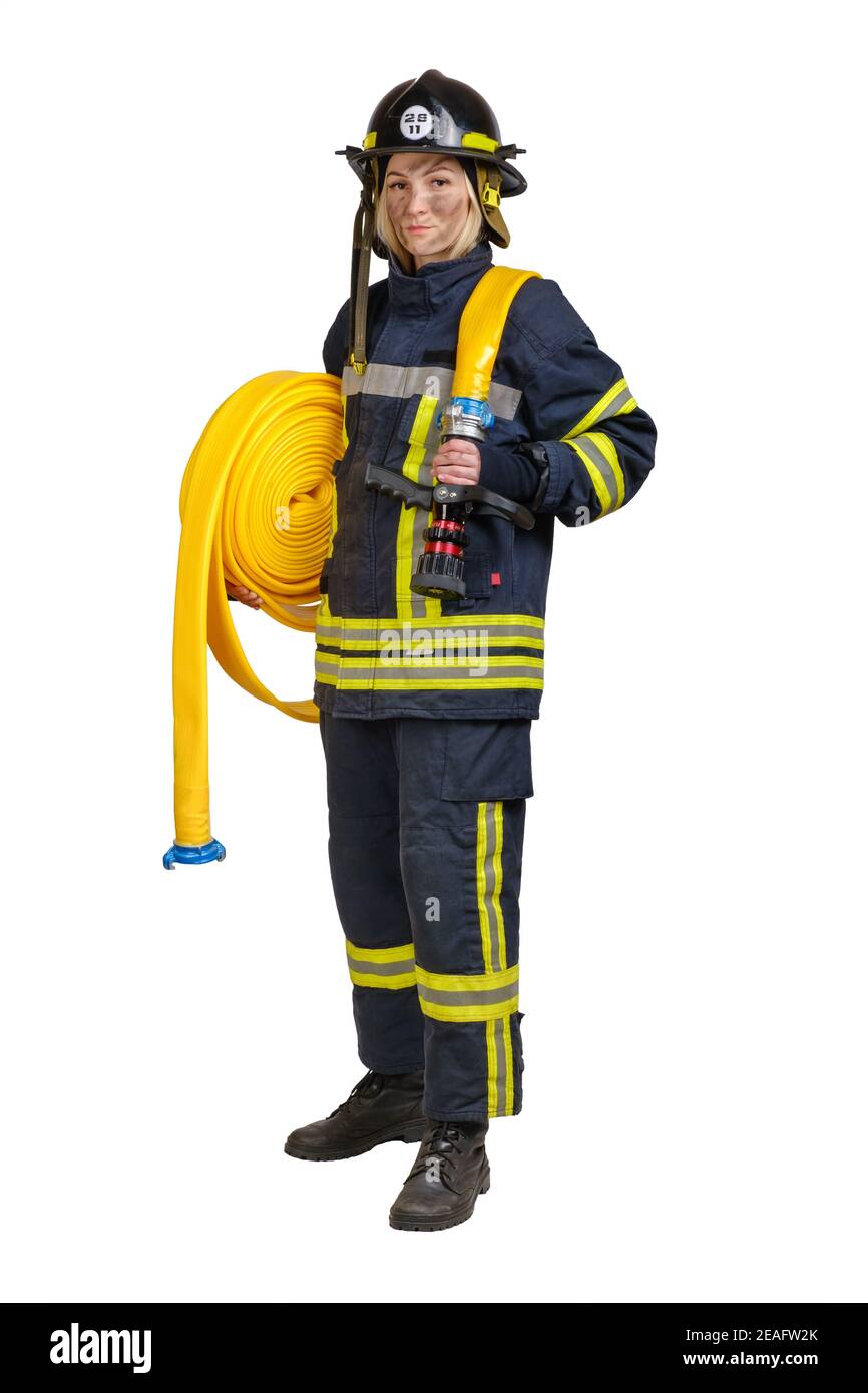 Giovane donna coraggiosa in uniforme e hardhat di pompiere con tubo antincendio Foto Stock