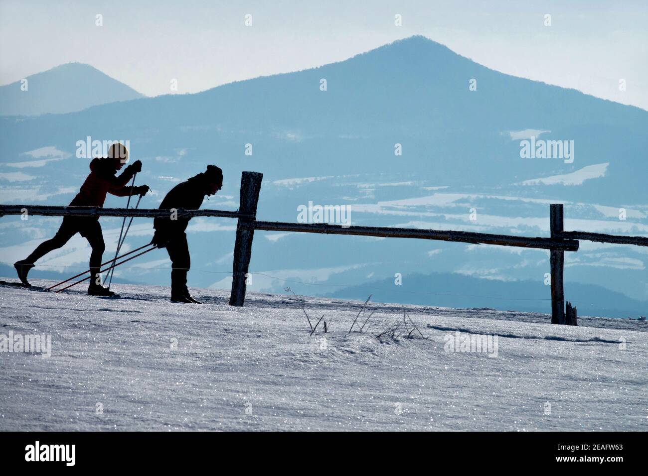 Due sciatori, sci di fondo, sagome invernali Foto Stock