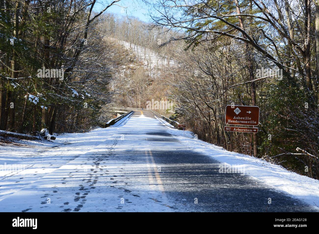 Impronte nel ghiaccio e neve che ricopra la strada su una sezione della Blue Ridge Parkway chiusa alle auto per l'inverno vicino Asheville, Carolina del Nord Foto Stock