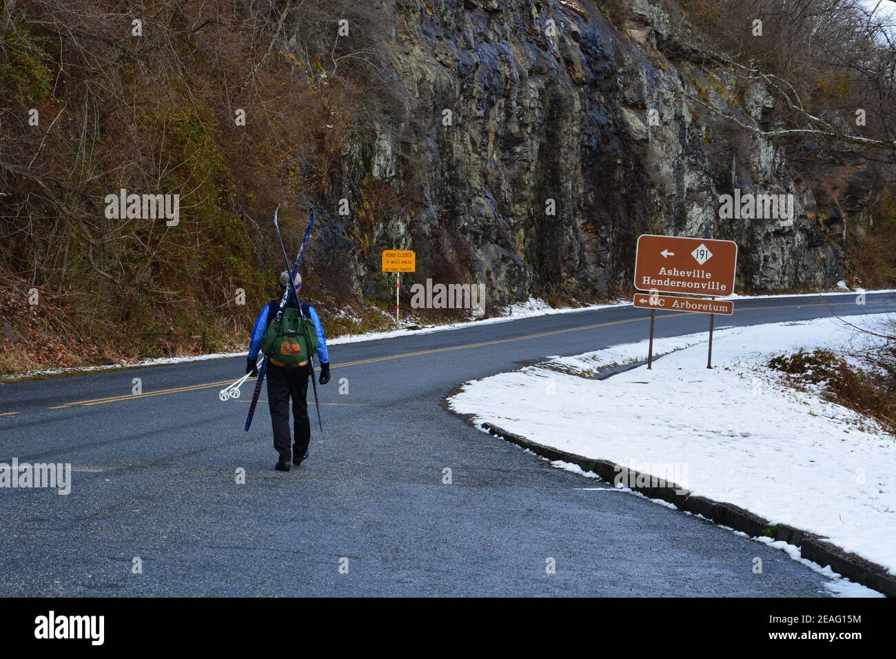 Uno sciatore di fondo cammina lungo una sezione della Blue Ridge Parkway che è chiusa per l'inverno vicino Asheville, Carolina del Nord Foto Stock