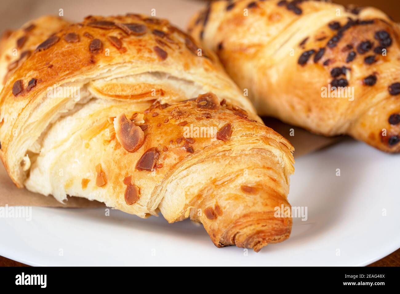 set di croissant appena sfornati su tavolo di legno. Croissant francese Foto Stock