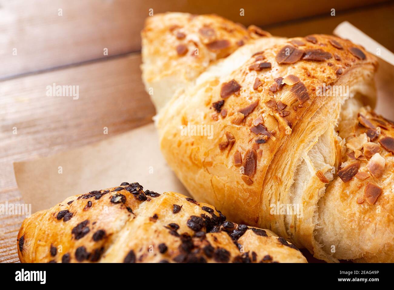 set di croissant appena sfornati su tavolo di legno. Croissant francese Foto Stock