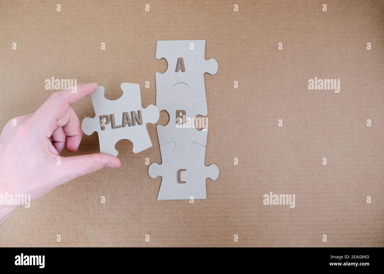 Persona raccoglie i dettagli di un puzzle con le iscrizioni piano a, b, c.. Foto Stock