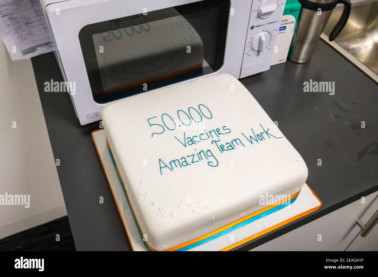 Torta presso il sito di vaccinazione Covid-19 a Woking, Surrey, nel sud-est dell'Inghilterra, che celebra 50,000 vaccini da parte del team del personale NHS locale Foto Stock