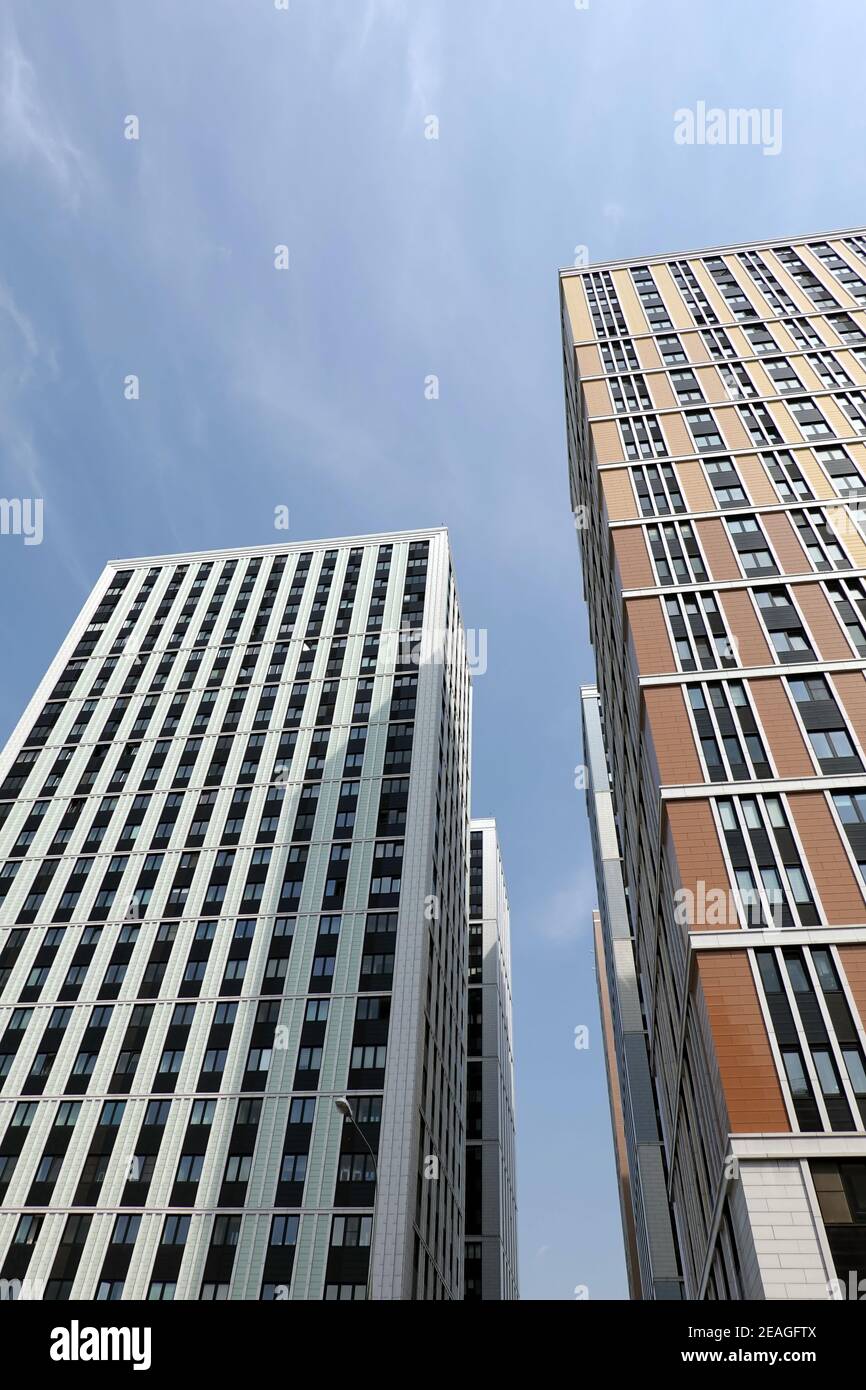Vista prospettica dal basso verso l'alto dei moderni grattacieli della città con molte finestre nel gruppo urbano Foto Stock