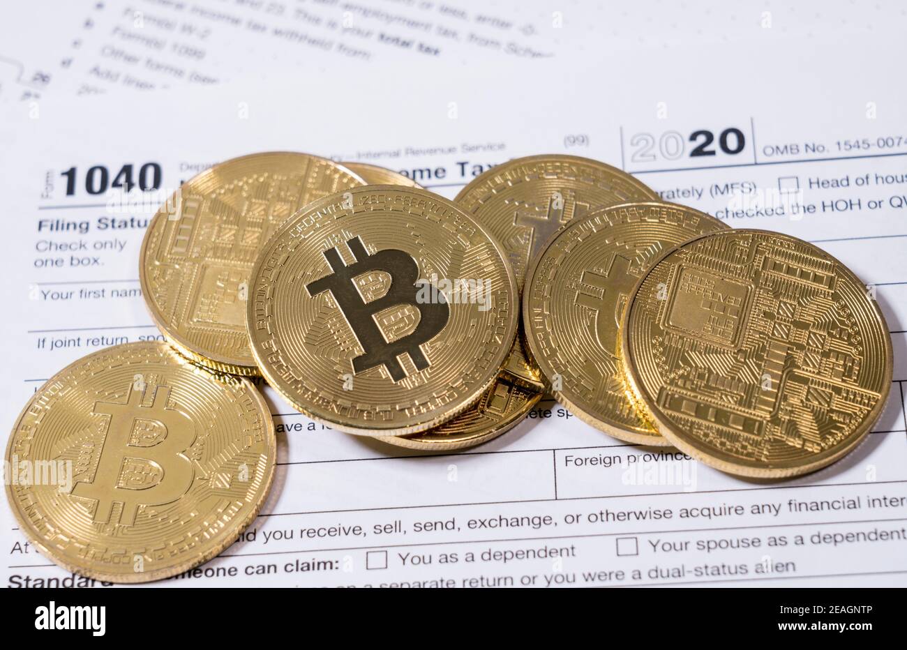 Modulo 1040 per il 2020 con monete di bitcoin per la segnalazione di guadagni dal commercio o dagli investimenti di cyber valuta Foto Stock