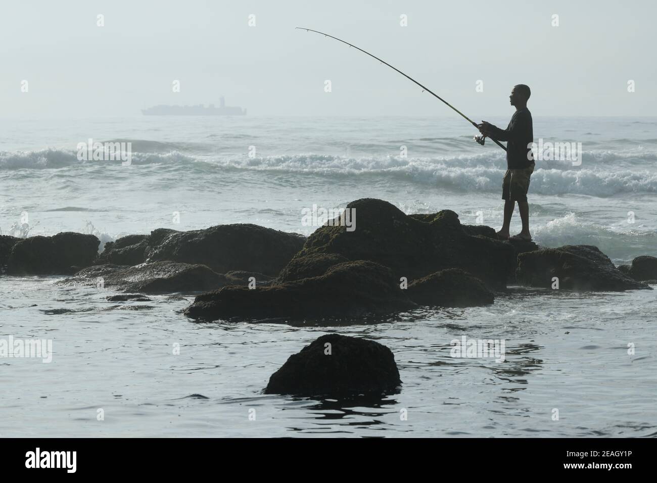 Pesca sportiva, persone, singolo adulto pescante pesce, mare, Umhlanga Rocks, Durban, Sudafrica, bella stagione, silhouette, attività all'aperto Foto Stock