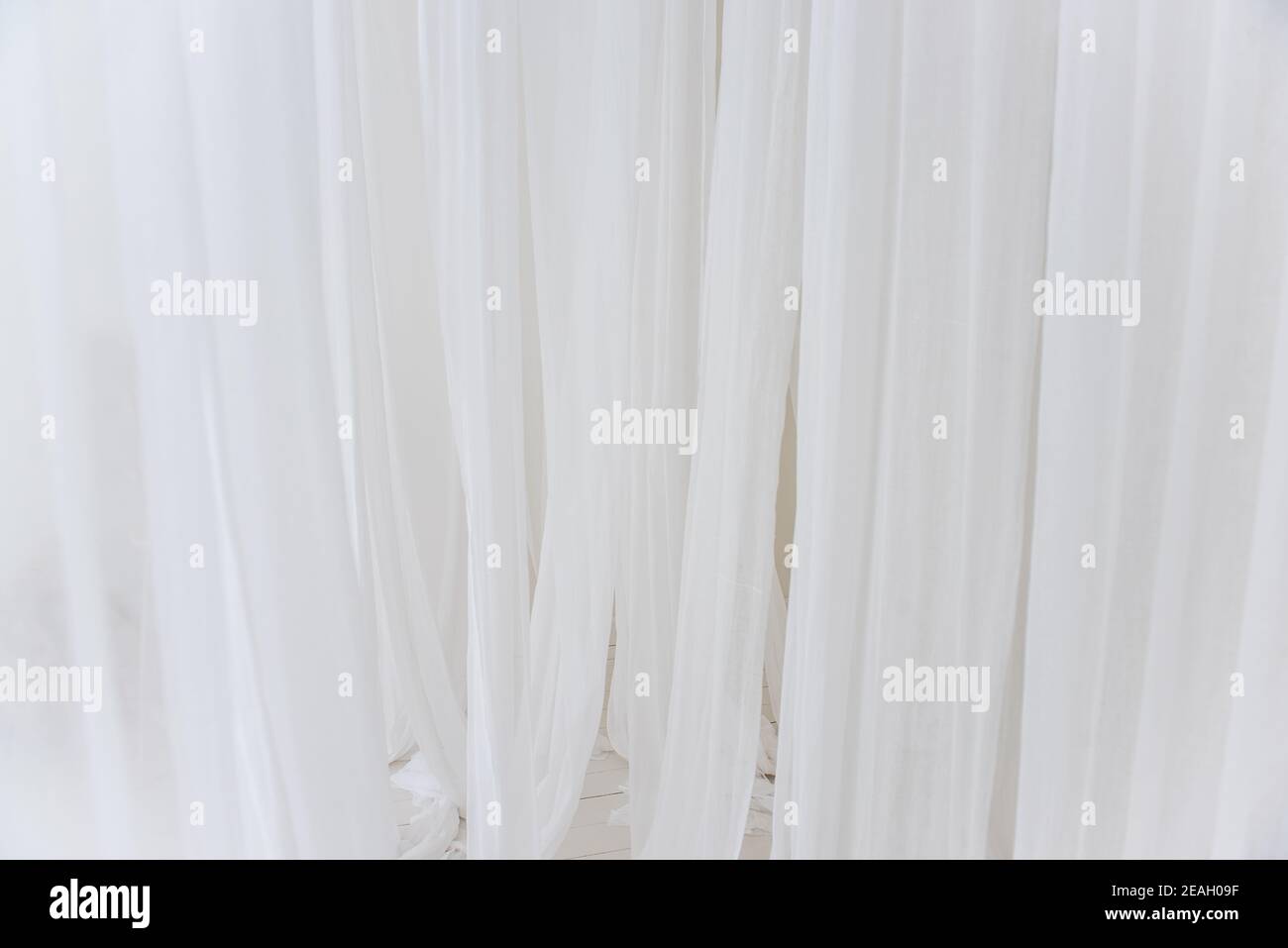 Trama di fondo di bianco, linee ariose di tessuto chiffon, tulle. Colori neutri. Decorazioni interne minimaliste. Stile scandinavo. Spazio di copia Foto Stock