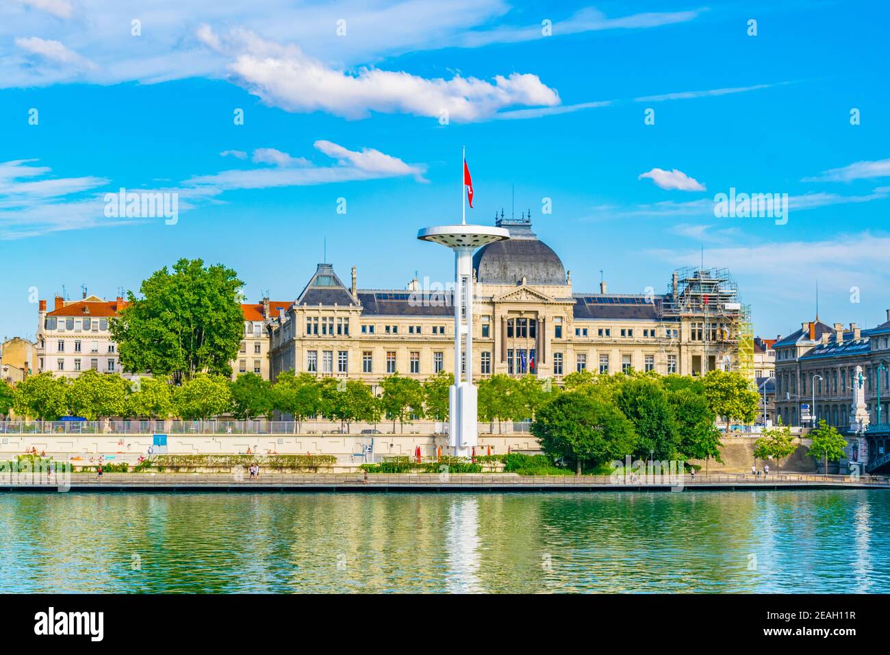 Pennoni giganti oltre ad una piscina pubblica sulla riva del fiume Rodano a Lione, Francia Foto Stock