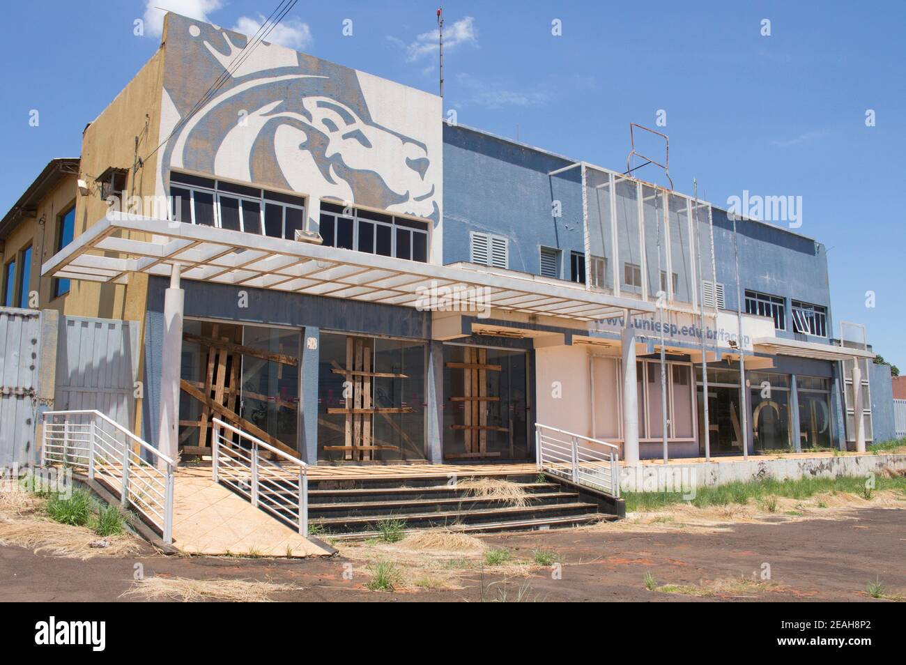 Ibitinga, SP, Brasile - Feb 09 2021: Facciata di abbandonato edificio universitario con barricata di legno sulle porte Foto Stock