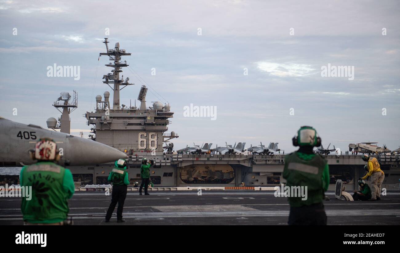 Handout foto di marinai statunitensi pronti un F/A-18E Super Hornet, assegnato ai "Golden Warriors" di Strike Fighter Squadron (VFA) 87, per il lancio dal ponte di volo della USS Theodore Roosevelt (CVN 71) mentre si svolgono operazioni a doppio vettore con il Nimitz Carrier Strike Group nel Mar Cinese Meridionale 9 febbraio, 2021. Due gruppi di sciopero di portaerei della Marina americana hanno iniziato le operazioni nelle acque contese del Mar Cinese Meridionale martedì, l'ultimo show di capacità navali da parte dell'amministrazione Biden, in quanto si impegna a resistere fermamente contro le rivendicazioni territoriali cinesi. I vettori USS Theodore Roosevelt Foto Stock