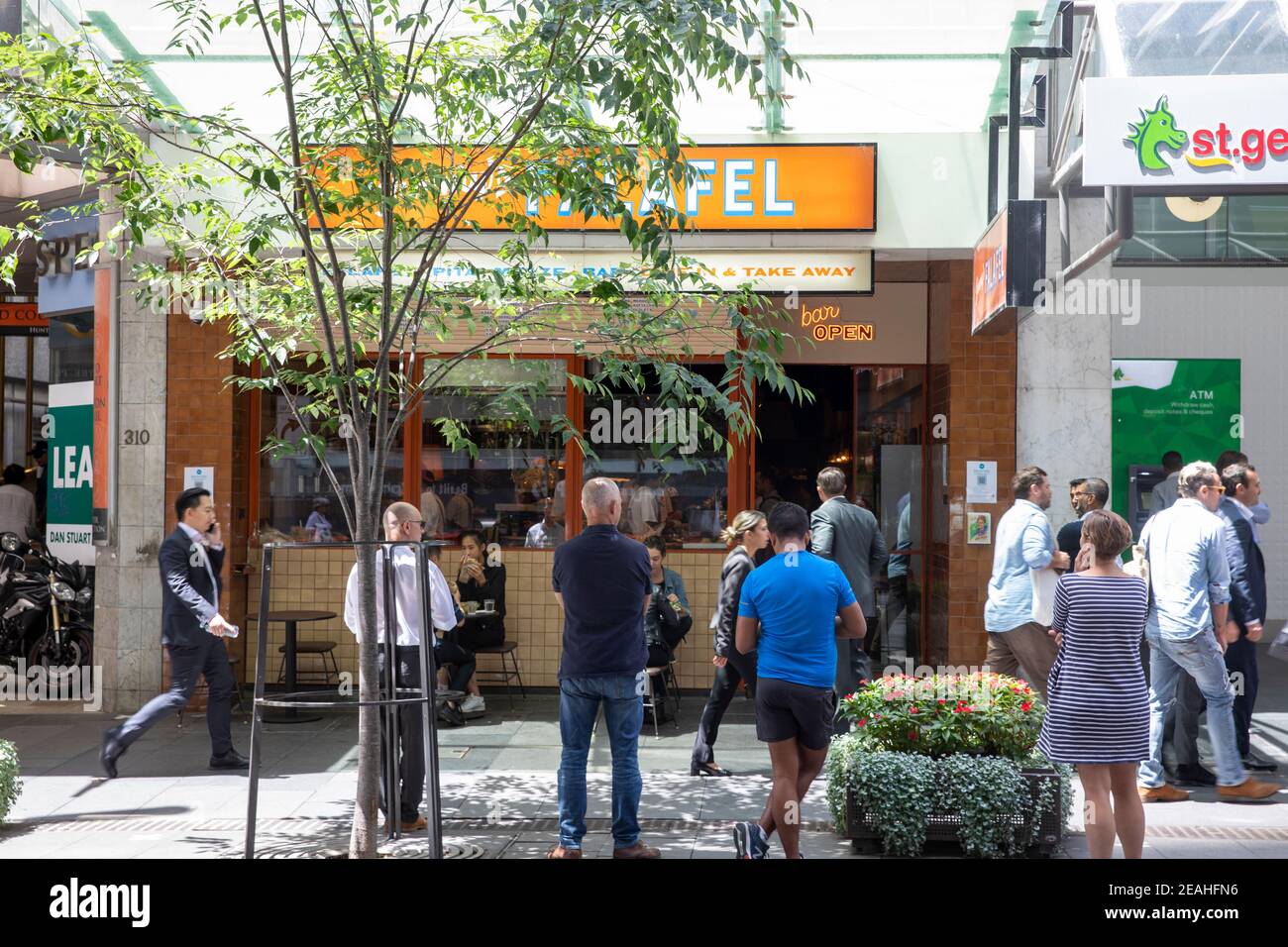 Lavoratori dell'ufficio di Sydney in attesa del pranzo da asporto ordine da falafel ristorante cafe su george Street in citta', Sydney, Australia Foto Stock