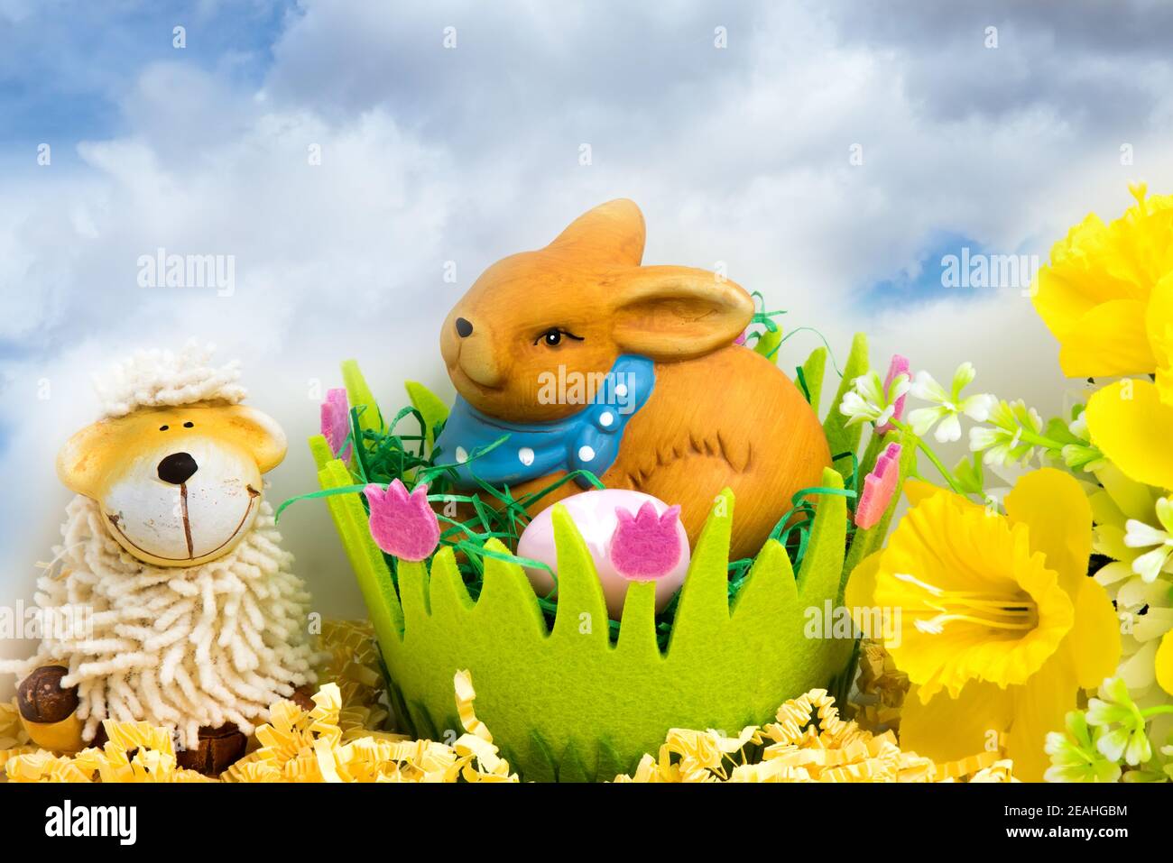 Coniglietto pasquale con uova in un cesto pasquale verde, decorazione floreale e spazio per il testo Foto Stock