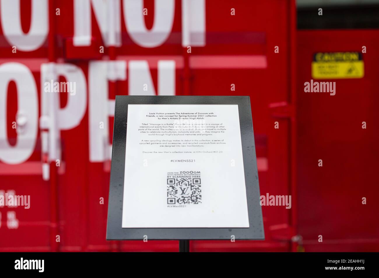 Introduzione cartello di Louis Vuitton rosso battente contenitori di spedizione sul retro. Singapore. Foto Stock