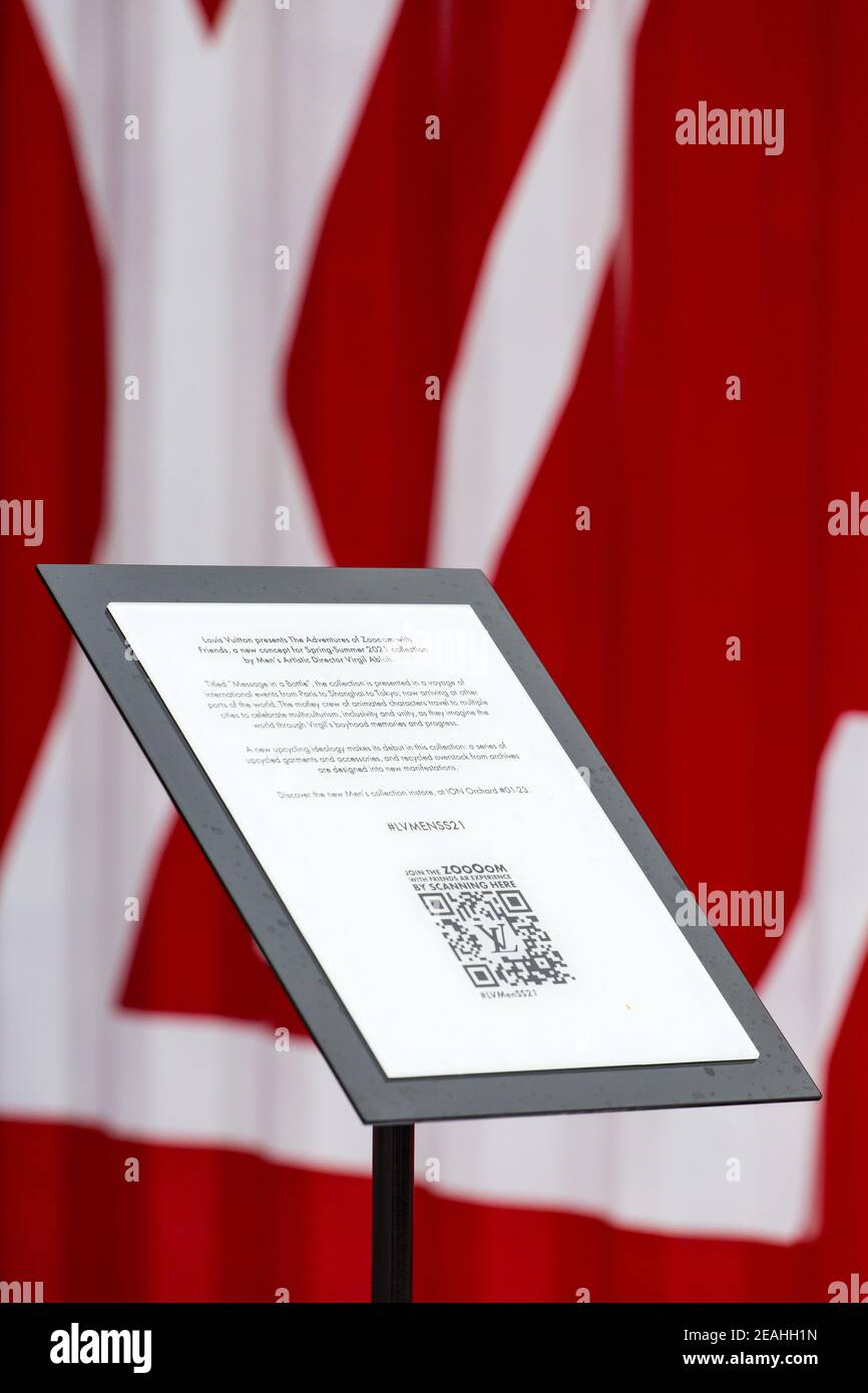 Vista verticale. Presentazione con cartello di Louis Vuitton rosso che colpisce i contenitori di spedizione sul retro. Singapore. Foto Stock