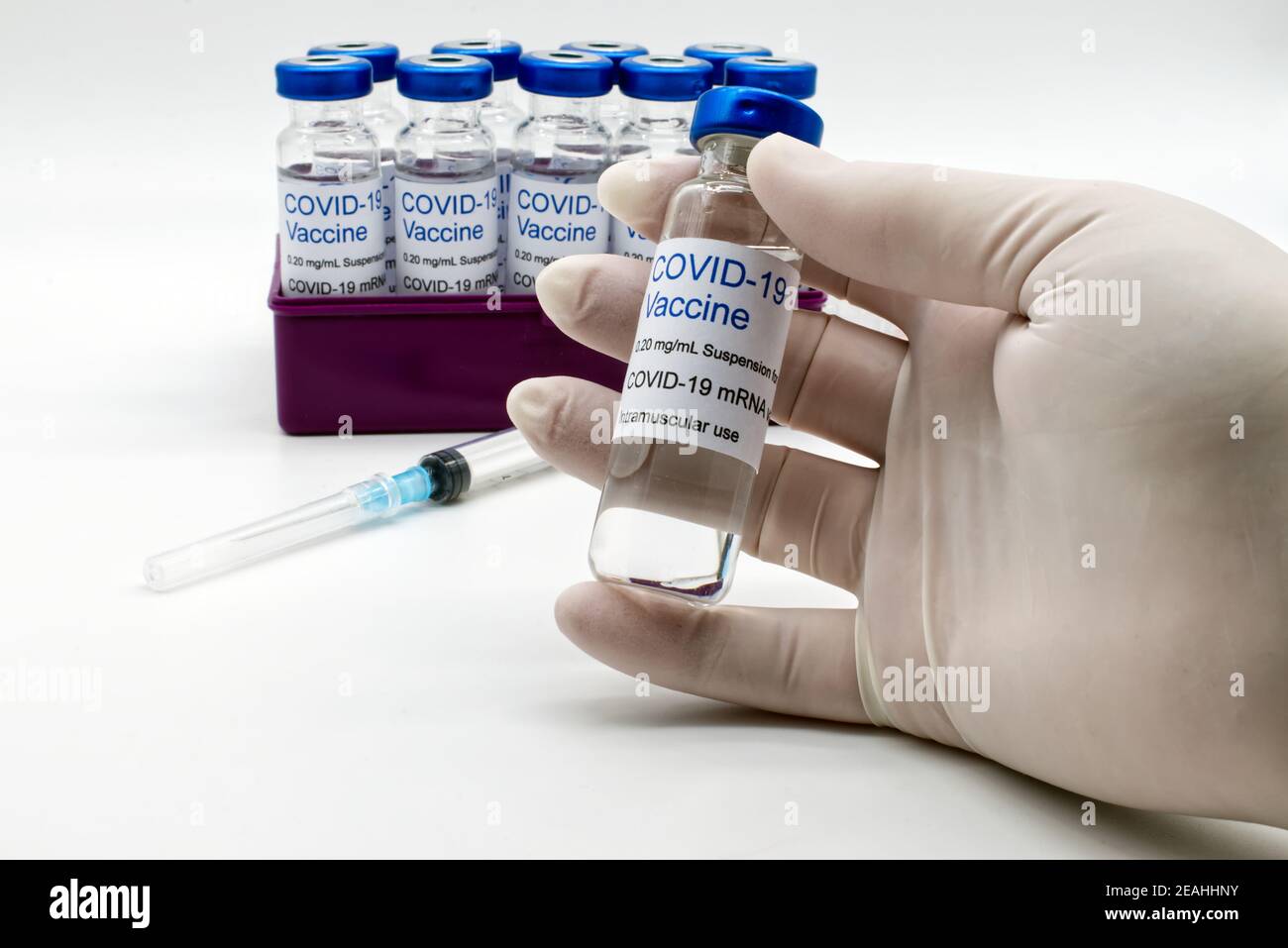 Medico mano in guanto medico di gomma che tiene un flaconcino di vaccino Covid-19. Foto Stock