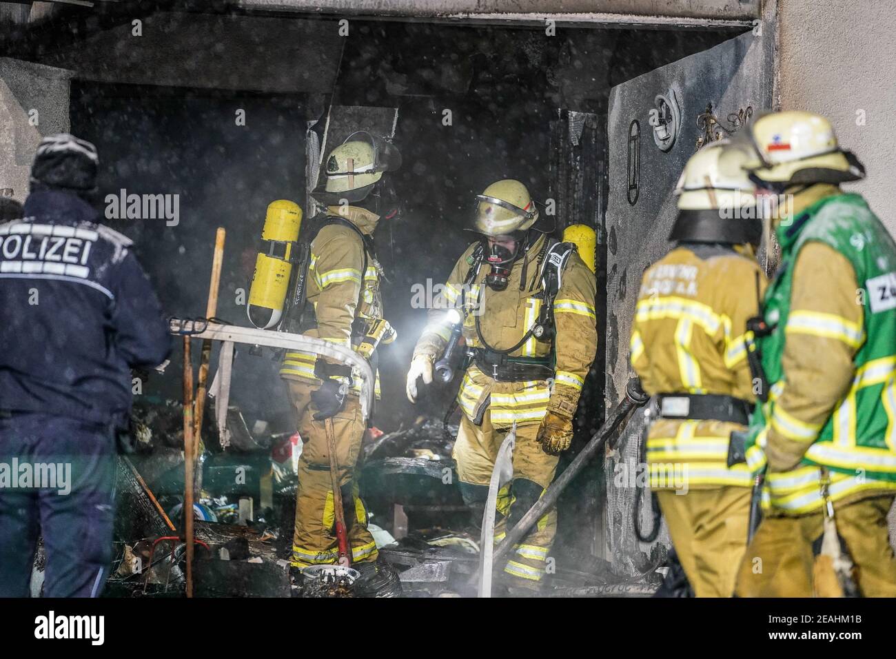 Esslingen, Germania. 10 Feb 2021. Vigili del fuoco e agenti di polizia si trovano al piano terra di un alto edificio dove è scoppiato un incendio. Un uomo di 60 anni è stato ferito nel fuoco del balcone. Il fuoco scoppiò sul balcone di un edificio di appartamenti, mercoledì mattina presto, ha detto la polizia. Poiché aveva nevicato così pesantemente, gli sforzi antincendio erano inizialmente difficili. Durante l'operazione su larga scala, circa 30 residenti hanno dovuto lasciare l'alto edificio. Credit: Kohls/SDMG/dpa/Alamy Live News Foto Stock