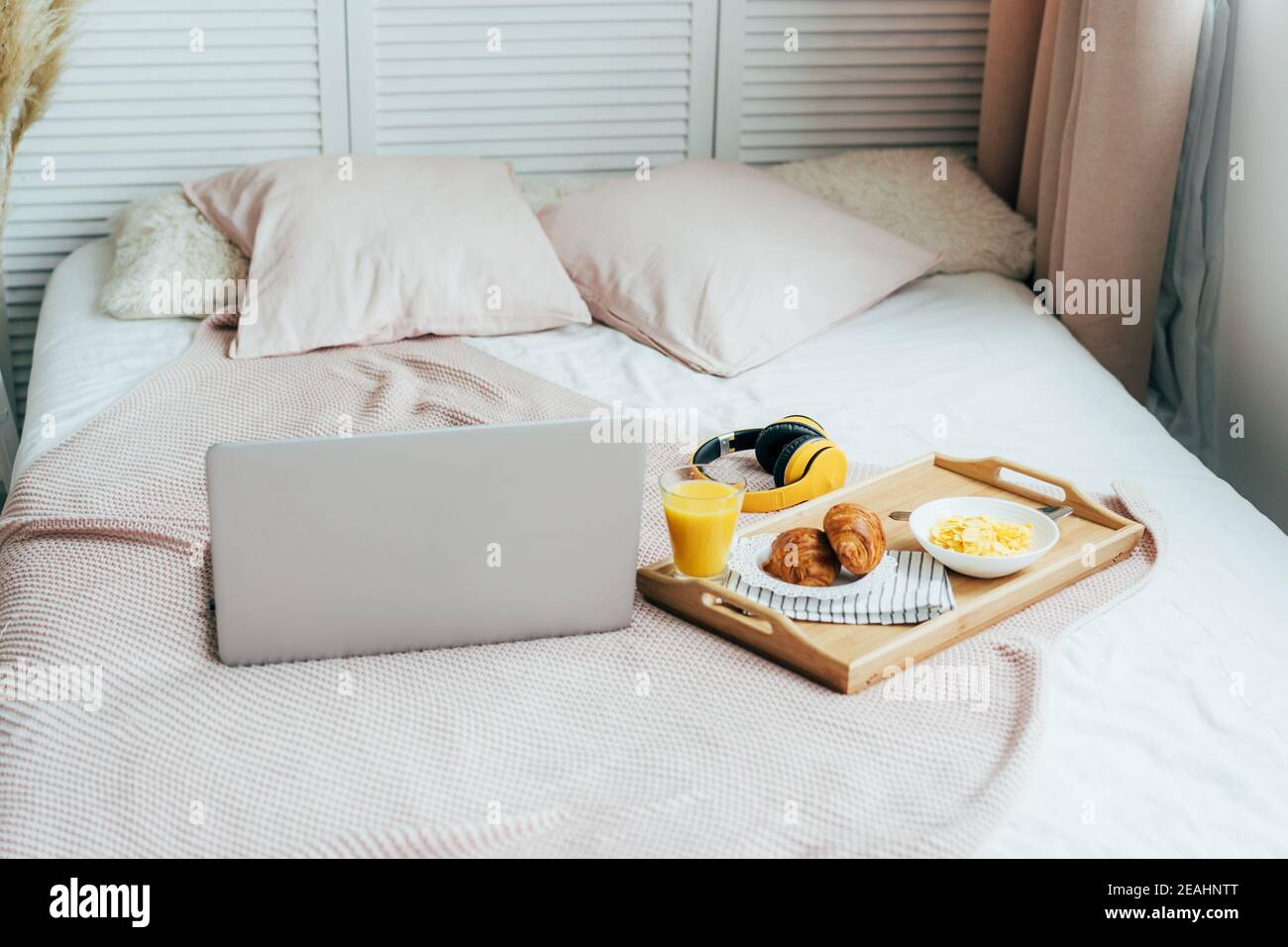 Colazione sana a letto con computer portatile. Affari domestici. Accogliente camera da letto vibrazioni. Foto Stock