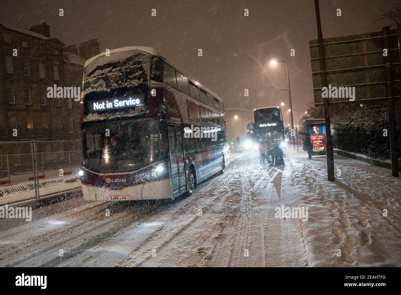 Edimburgo, Scozia, Regno Unito. 10 Feb 2021. Il grande congelamento continua nel Regno Unito con la notte pesante e la mattina neve che porta il traffico a un arresto su molte strade nel centro della città. PIC; gli autobus Lothian lottano sulla Leith Walk alle 6:00. Iain Masterton/Alamy Notizie dal vivo Foto Stock