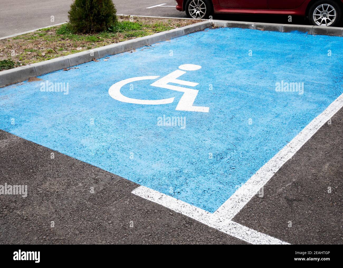 Simbolo per disabili dipinto su un posto auto Foto Stock