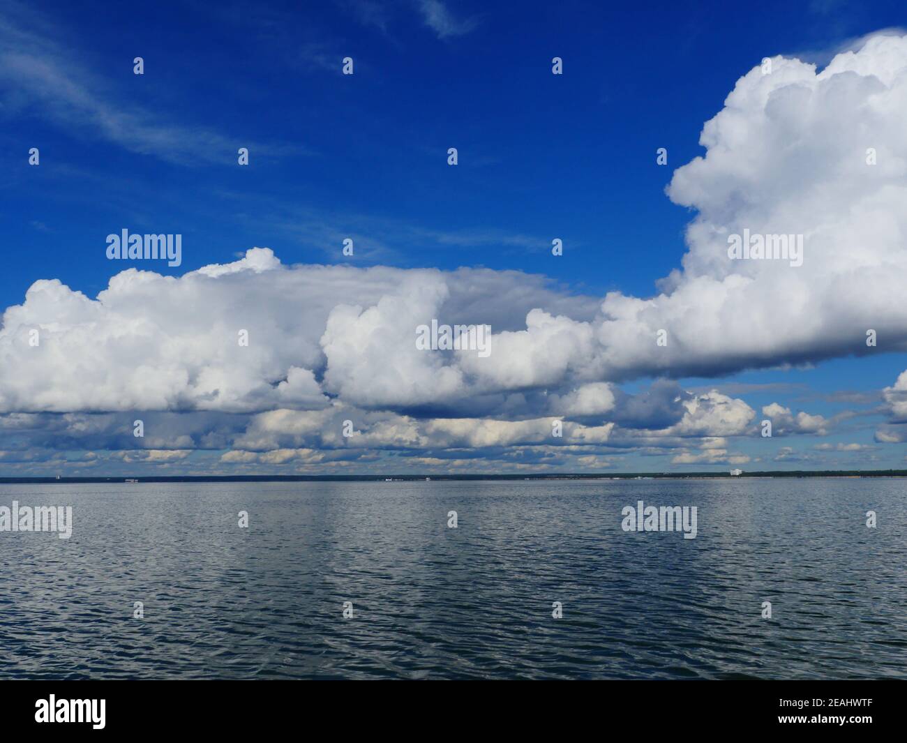 le nuvole si riflettono nelle onde del mare Foto Stock