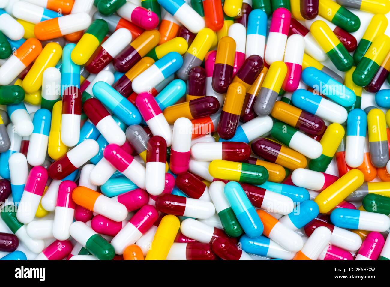 Vista dall'alto pillole di capsule colorate. Pila completa di pillole di capsule di colori brillanti. Industria farmaceutica. Prodotti farmaceutici per l'assistenza sanitaria. Concetto di sviluppo dei farmaci. Bilancio e politica sanitaria. Foto Stock