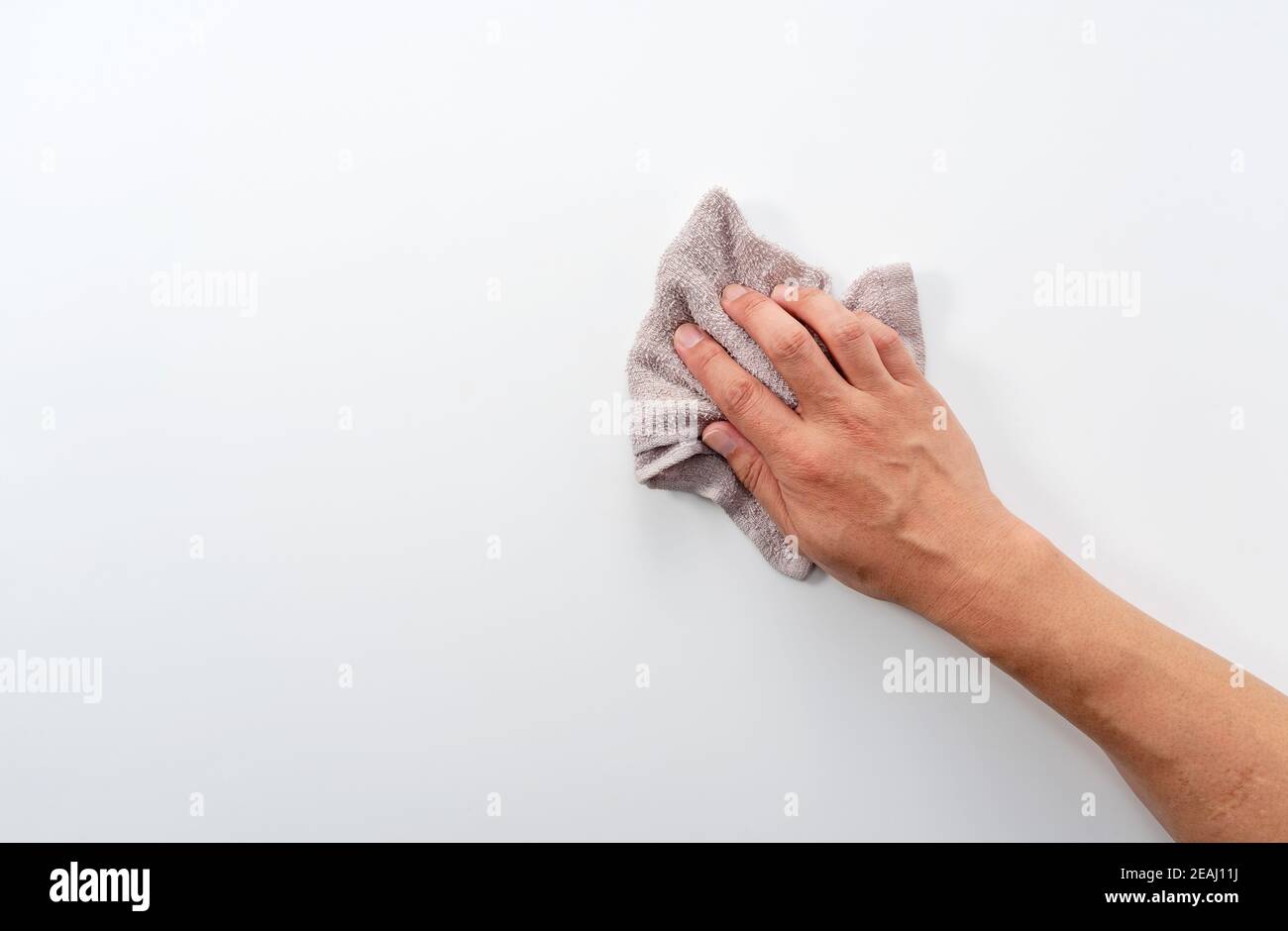 Una mano dell'uomo su uno sfondo bianco con uno straccio Foto Stock