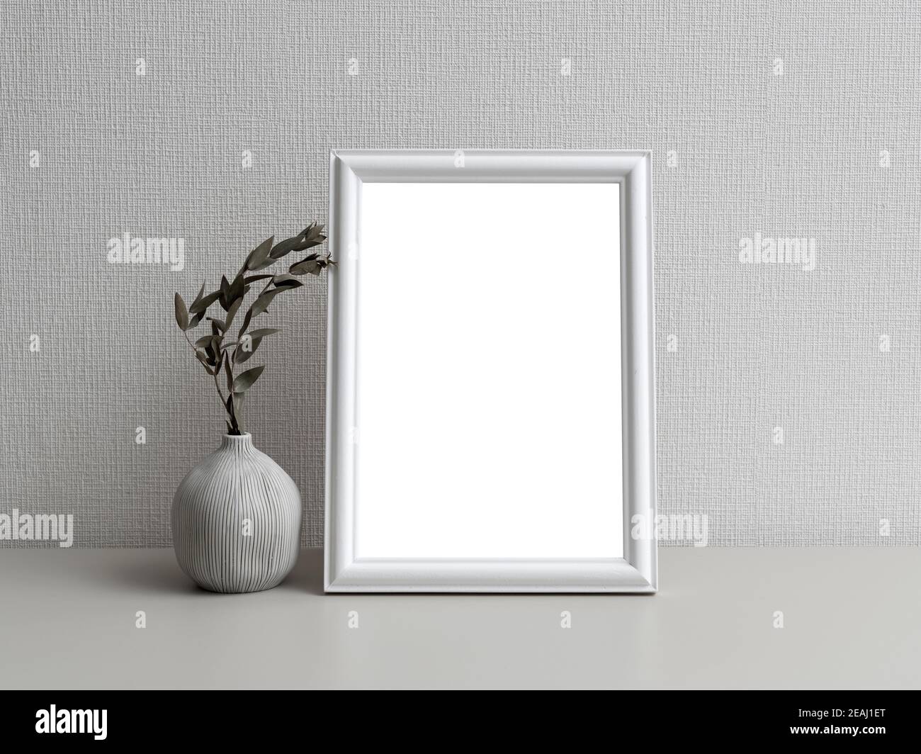 Una cornice fotografica semplice di fronte a una parete bianca Foto Stock