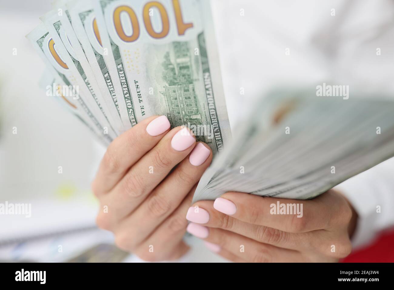 Le mani femminili stanno contando le fatture americane di cento dollari Foto Stock