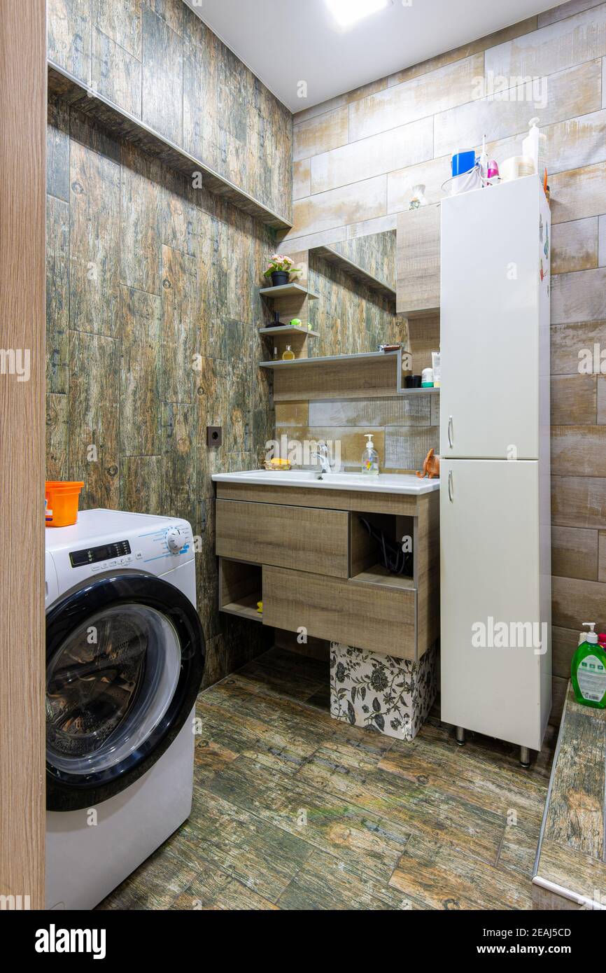 Interno di un accogliente bagno compatto e moderno con lavatrice macchina Foto Stock