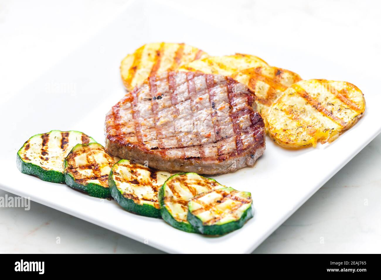 tonno alla griglia con patate e zucchine Foto Stock