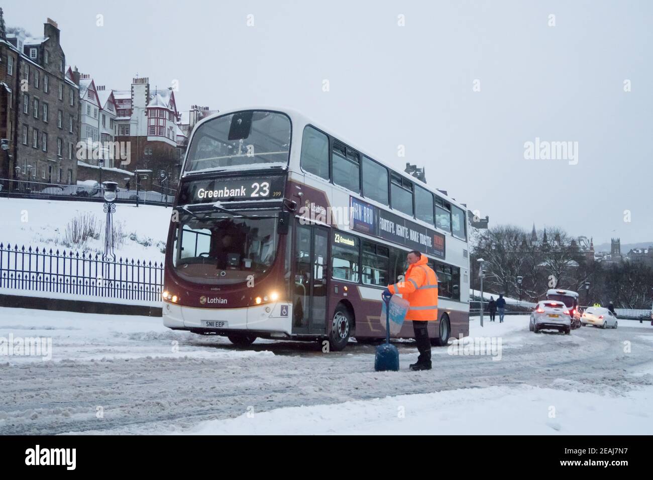 Edimburgo, Scozia, Regno Unito. 10 febbraio 2021. A causa di una forte nevicata, il centro di Edimburgo è stato fermato questa mattina. Un uomo è visto con una vanga che aiuta l'automobilista in cima alla Mound a Edimburgo. Credit: Lorenzo Dalberto/Alamy Live News Foto Stock