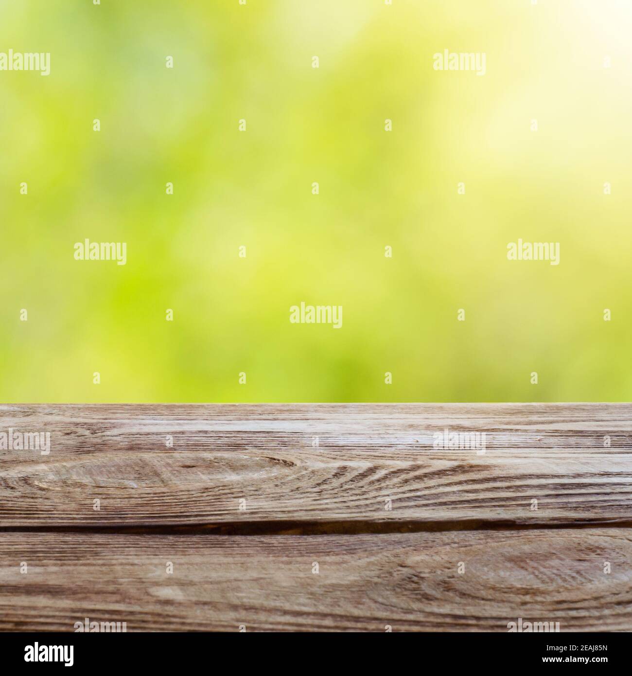 Tavolo in legno su lucido sfondo verde bokeh. Per la visualizzazione del prodotto. Foto Stock
