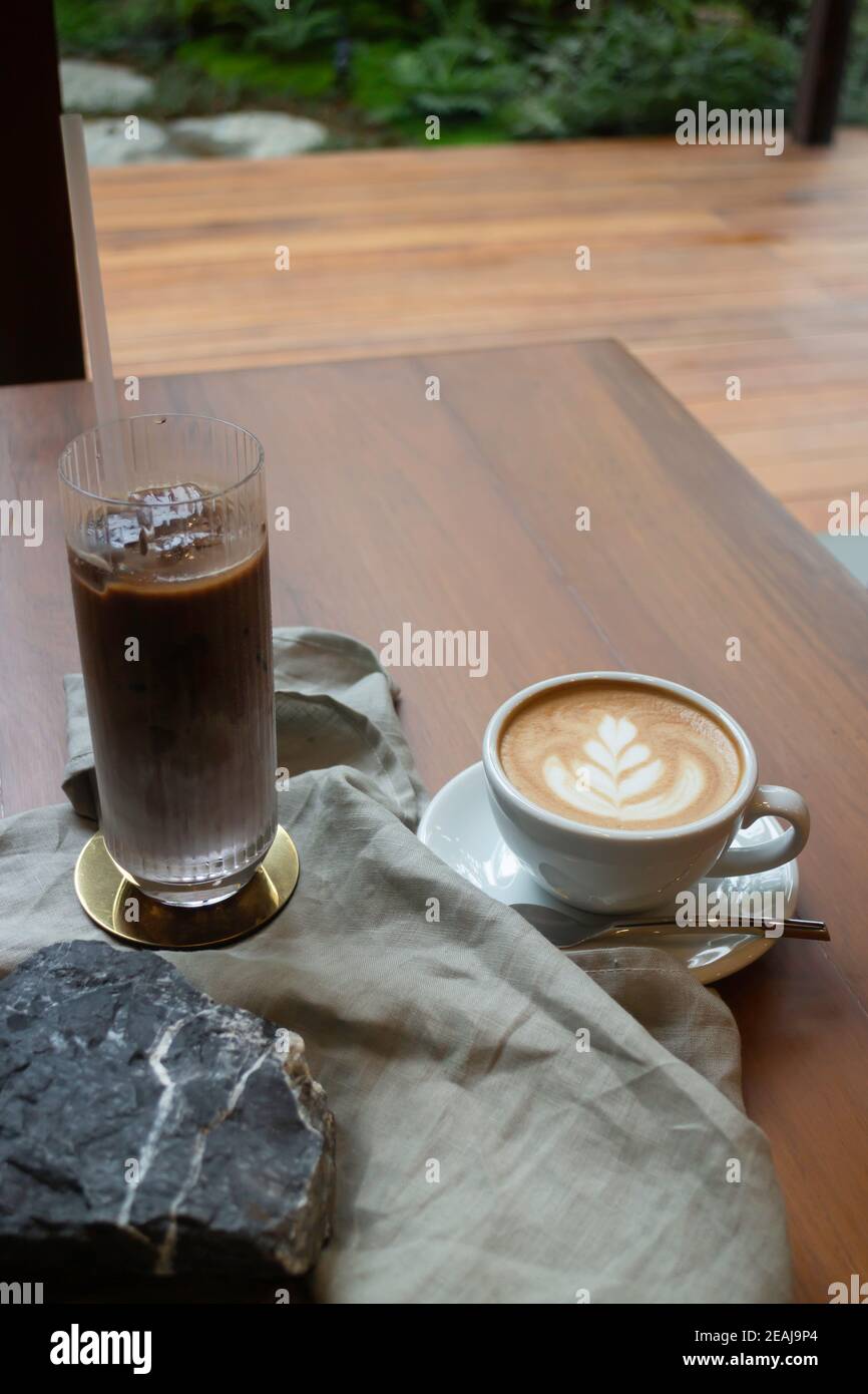 Caffè caldo e caffè ghiacciato sul tavolo di legno Foto Stock