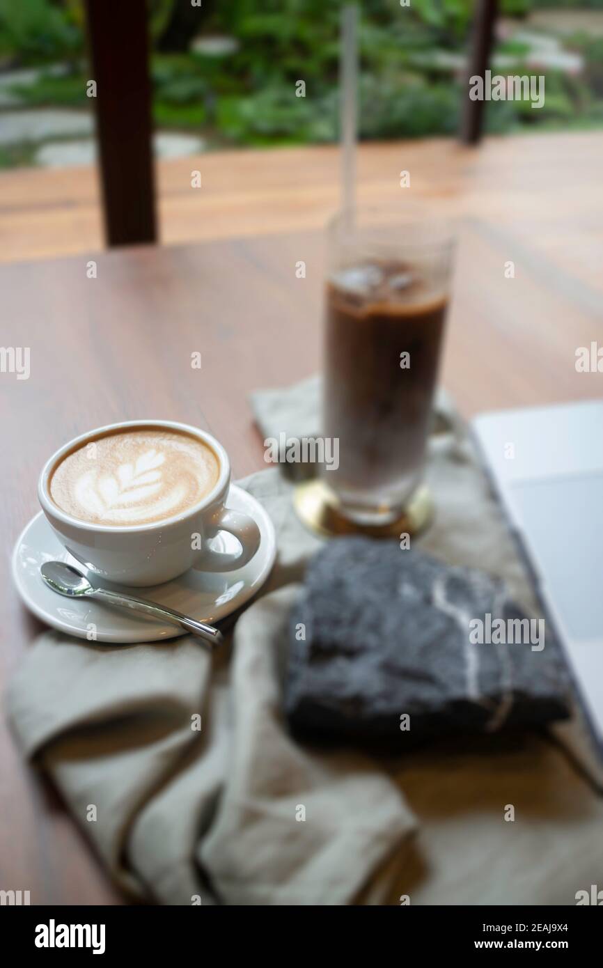 Caffè caldo e caffè ghiacciato sul tavolo di legno Foto Stock