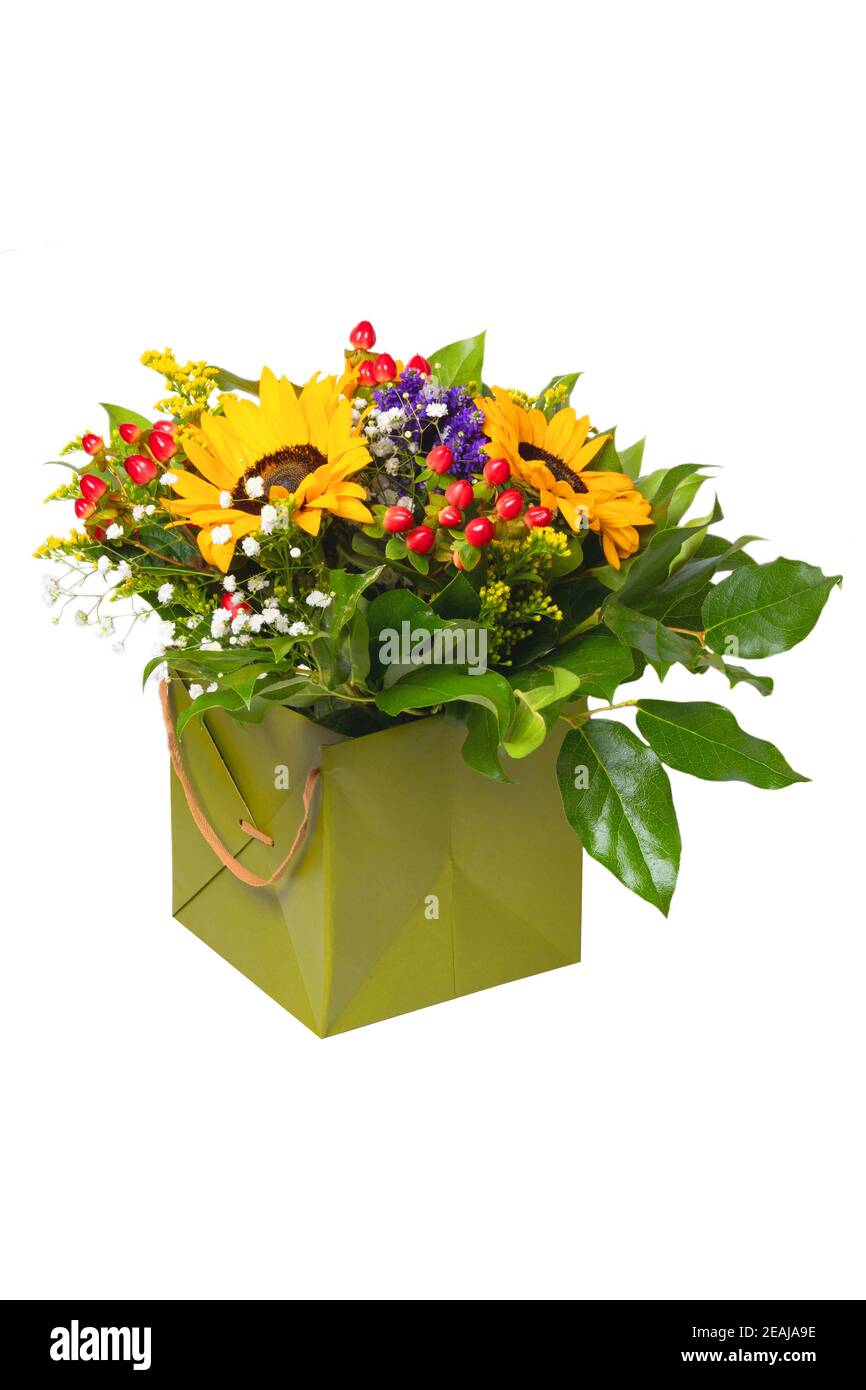 Fiore decorazione sfondo. Primo piano di un bel bouquet con girasoli gialli in una scatola regalo decorativa verde isolata su sfondo bianco. Macro. Foto Stock