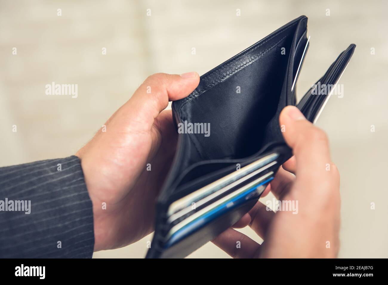 Closeup di mani di uomo d'affari che mostrano rotto portafoglio in pelle vuoto con nessun denaro Foto Stock