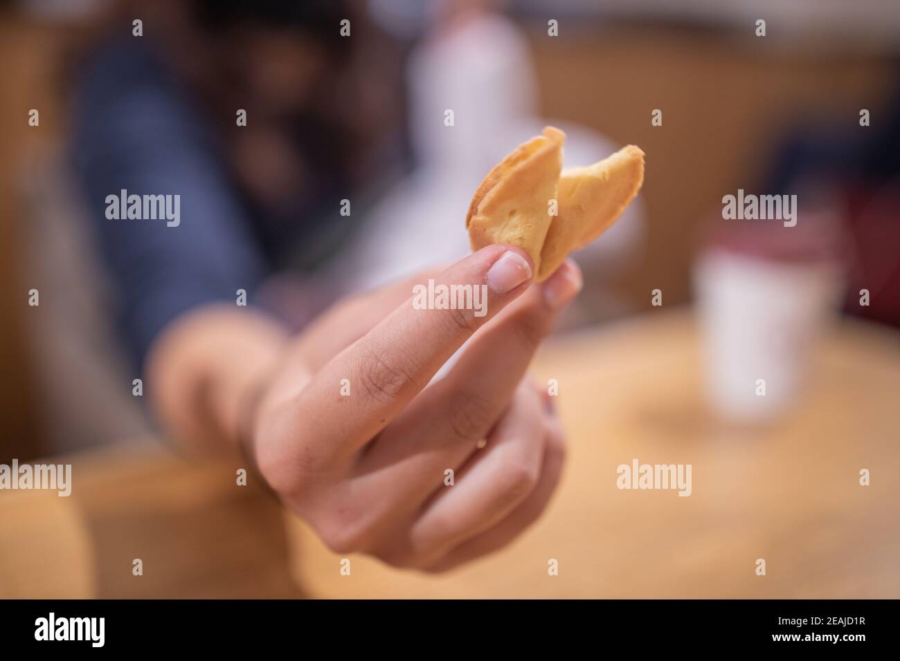 La mano di una donna mostra direttamente un cookie Furtune Sulla fotocamera Foto Stock