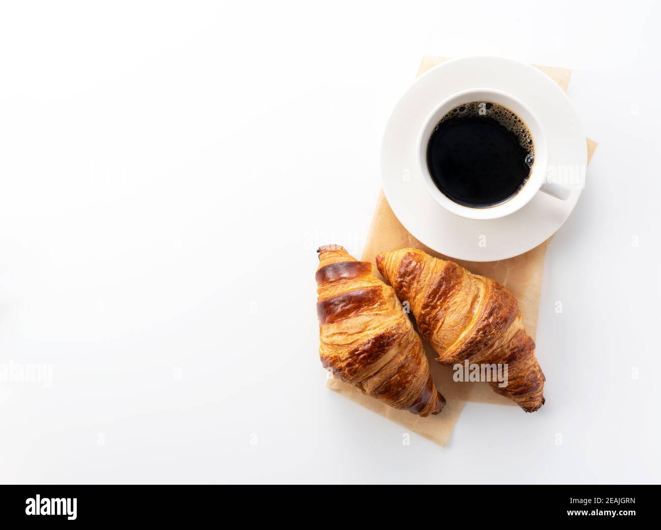 Croissant e caffè caldo su sfondo bianco Foto Stock