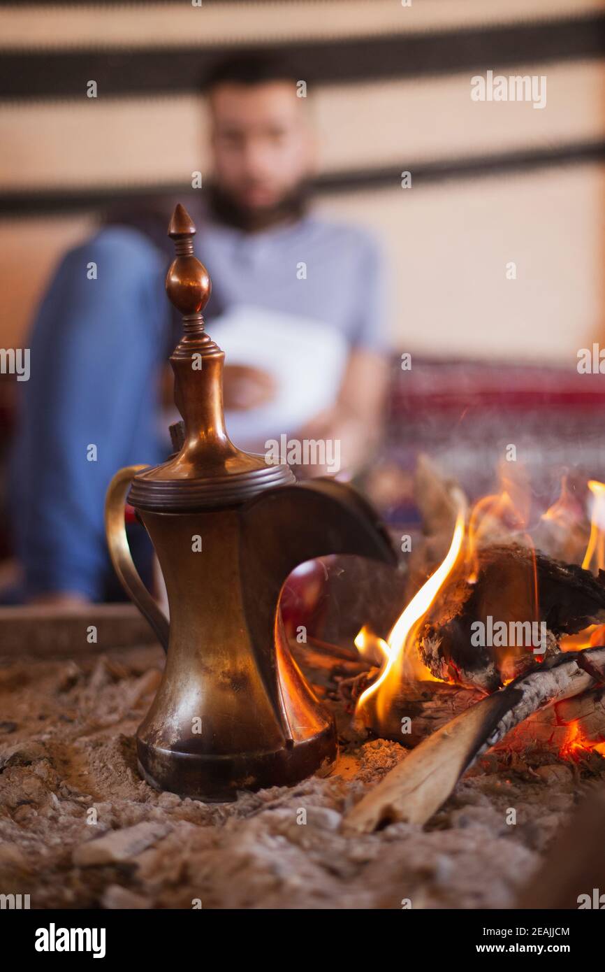 Tradizionale caffettiera arabica chiamata dallah nel camino all'interno del tenda Foto Stock
